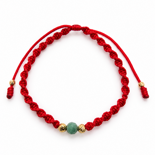 18K solid gold raw emerald bracelet on a red spiral macramé cord with adjustable sliding closure, full view on white background
